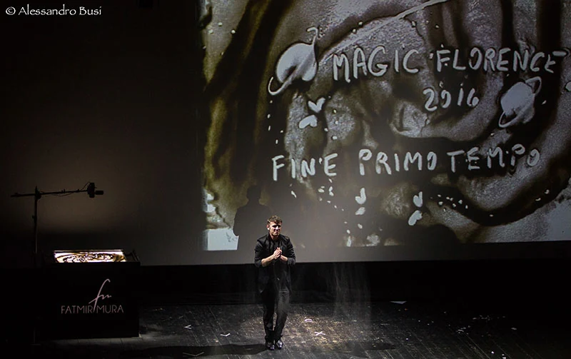 Fatmir Mura performing on a large theatre screen